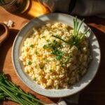 Risoto cremoso de ervilha feito com Arroz Arbóreo Caldo Bom servido em prato fundo, decorado com queijo parmesão e ervilhas frescas, destacando a textura cremosa e a cor vibrante das ervilhas.