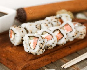 Uramaki de salmão com cream cheese, sushi com arroz por fora e gergelim, ideal para quem busca sushi com salmão e cream cheese.